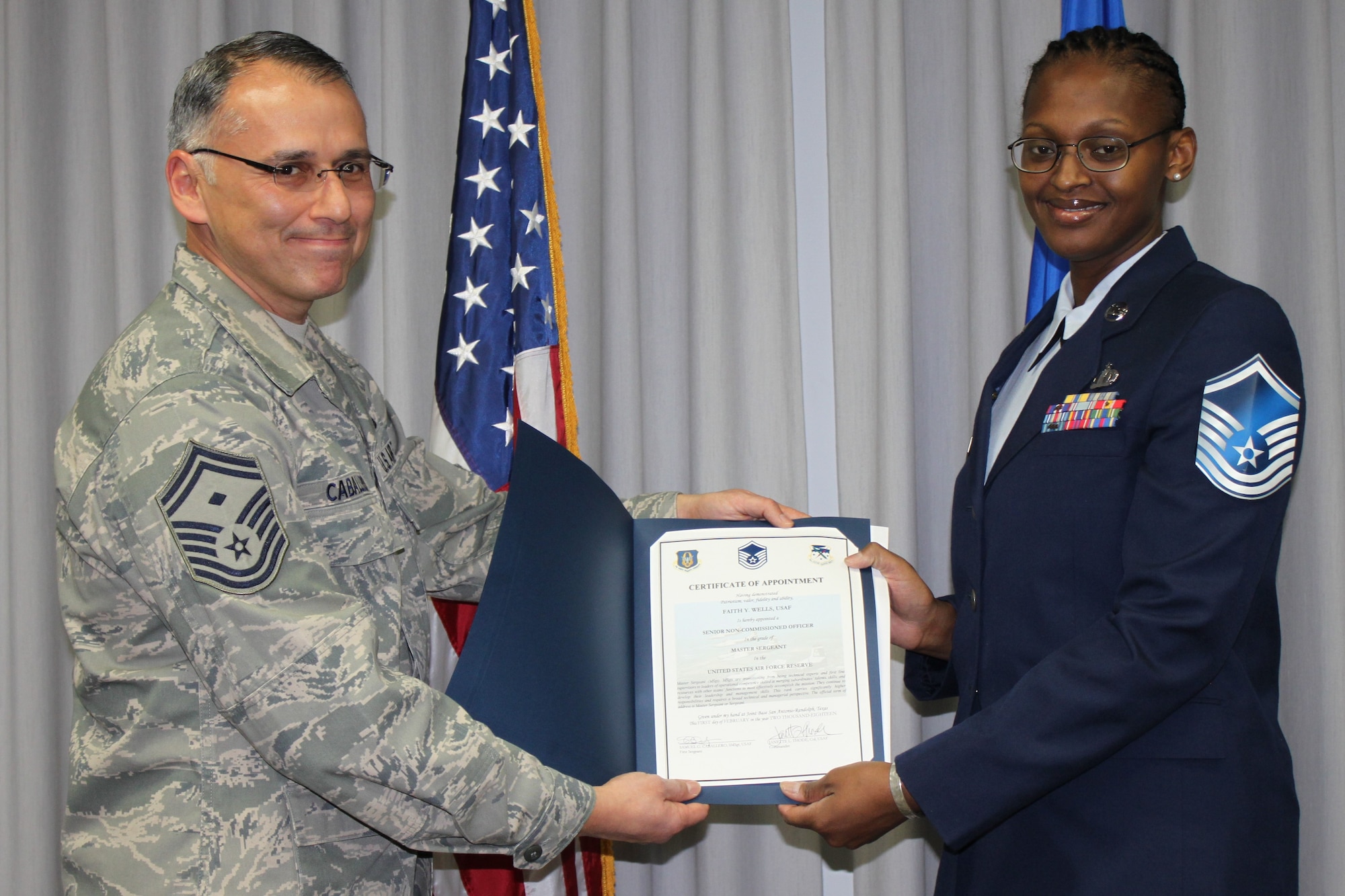 Senior Master Sgt. Samuel Caballero, 340th Flying Training Group first sergeant, and newly promoted Master Sgt. Faith Wells display the certificate inducting her into the senior enlisted tier after promotion ceremonies at Joint Base San Antonio-Randolph, Texas. (U.S. Air Force photo by Tech. Sgt. Brianne Blackstock)