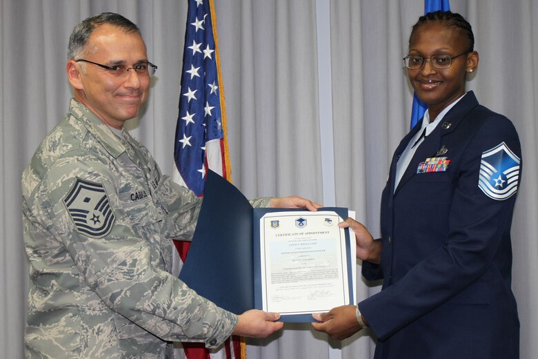 Senior Master Sgt. Samuel Caballero, 340th Flying Training Group first sergeant, and newly promoted Master Sgt. Faith Wells display the certificate inducting her into the senior enlisted tier after promotion ceremonies at Joint Base San Antonio-Randolph, Texas. (U.S. Air Force photo by Tech. Sgt. Brianne Blackstock)