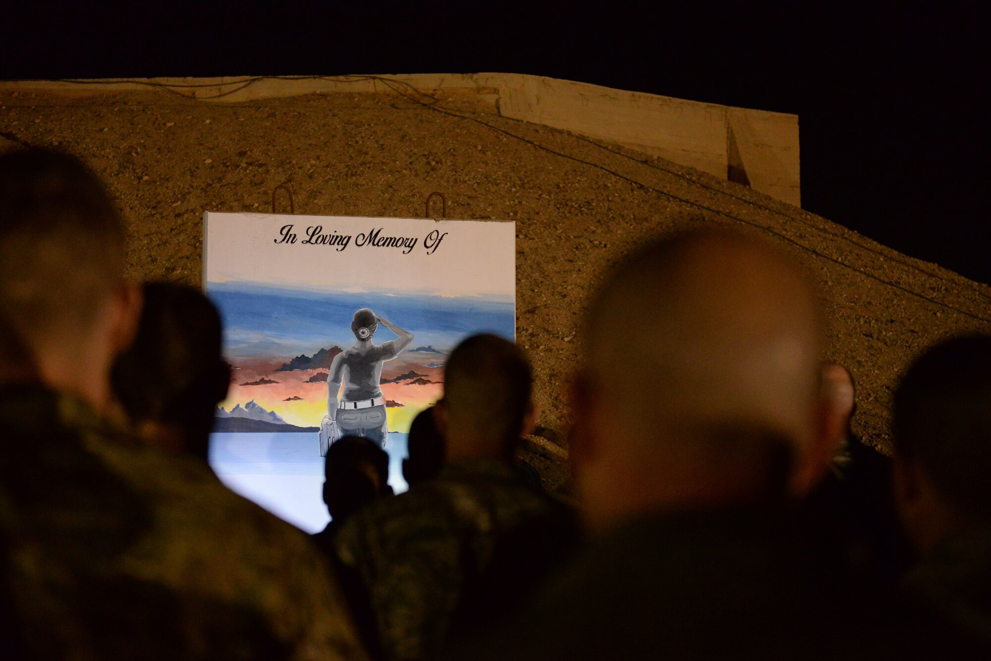 Members of the 332nd Air Expeditionary Wing gathered around the T-wall of Staff Sgt. Alexandria Morrow at 12:21 a.m. March 22, 2018, at an undisclosed location in Southwest Asia to pay their respects. She passed away during a bomb loading accident March 22, 2017. One of her nicknames was “Mother Alex” because of how she took care of everyone on the flight line. Members played Taps, held a moment of silence and performed a flag folding ceremony. The flag along with pictures of the ceremony will be sent to Morrow’s husband and two children. (U.S. Air Force photo by Senior Master Sgt. Cohen A. Young)
