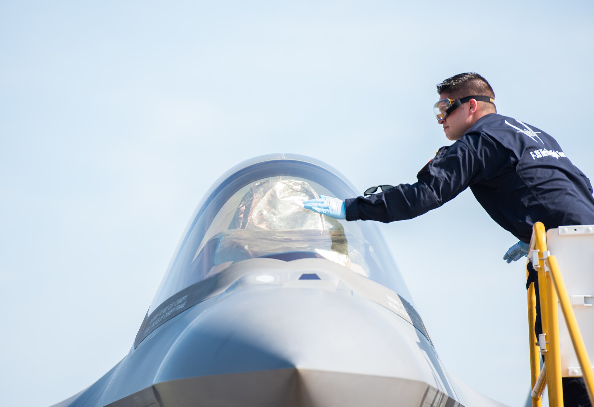 Staff Sgt. John Baker, F-35 Heritage Flight Team crew chief cleans the canopy of an F-35A Lightning II during the Wings Over South Texas air show at Naval Air Station Kingsville, Texas, March 25, 2018. The F-35 HFT consists of one pilot and 12 maintainers who seamlessly work together to maintain the world’s most technologically advanced fighter aircraft. (U.S. Air Force photo by Airman 1st Class Alexander Cook)