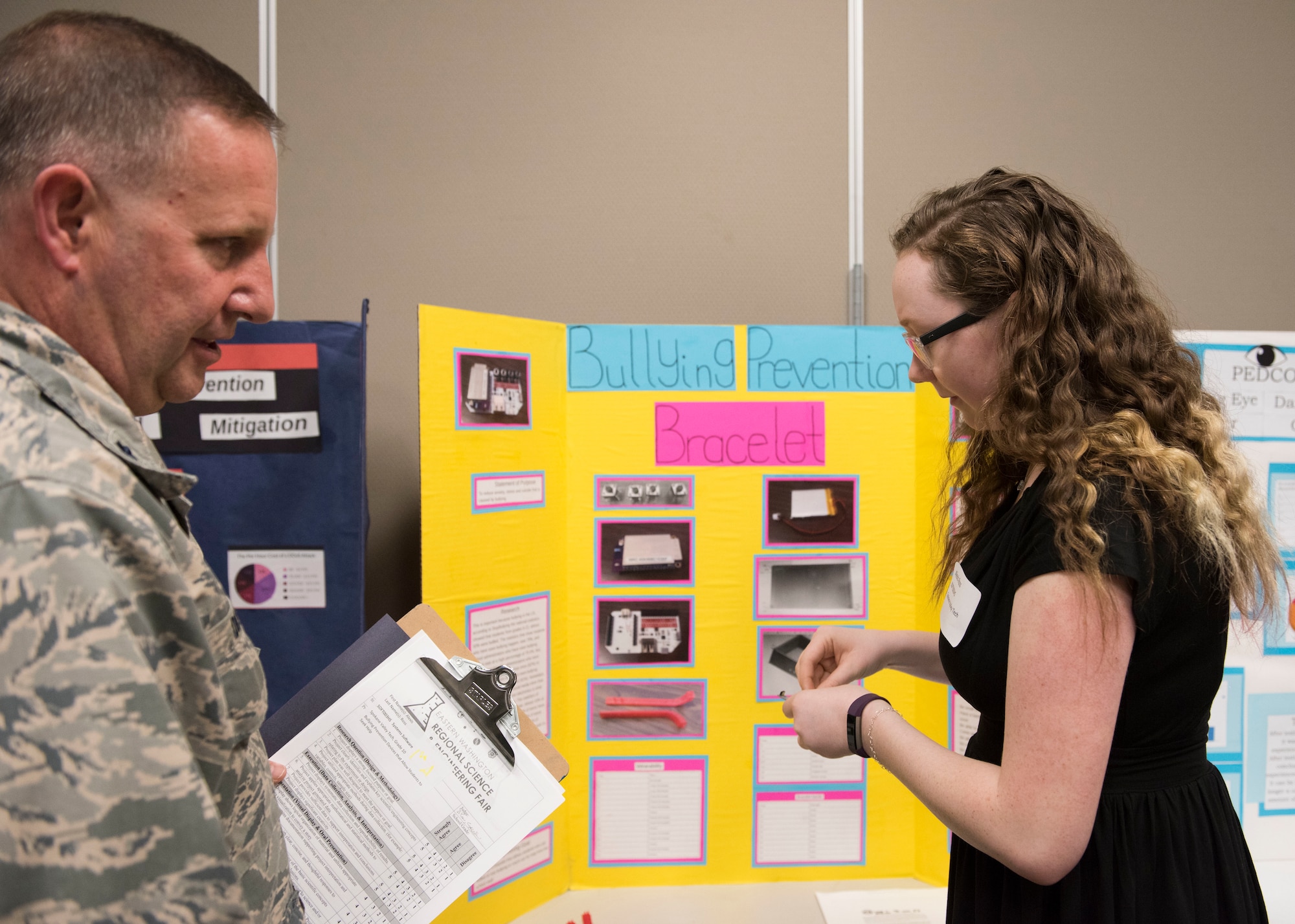 Lt. Col. Gavin Dillon, 92nd Medical Group Bioenvironmental Engineering commander, reviews the project of Alexis Ross, Spokane Valley Tech student, during the Eastern Washington Regional Science and Engineering Fair at the Spokane Washington State University campus, Washington, March 15, 2018. Team Fairchild attended the fair as part of the Installation Diversity Initiative, which aims to diversify and uplift the U.S. Air Force by recruiting the best and brightest minds. (U.S. Air Force photo/Senior Airman Ryan Lackey)