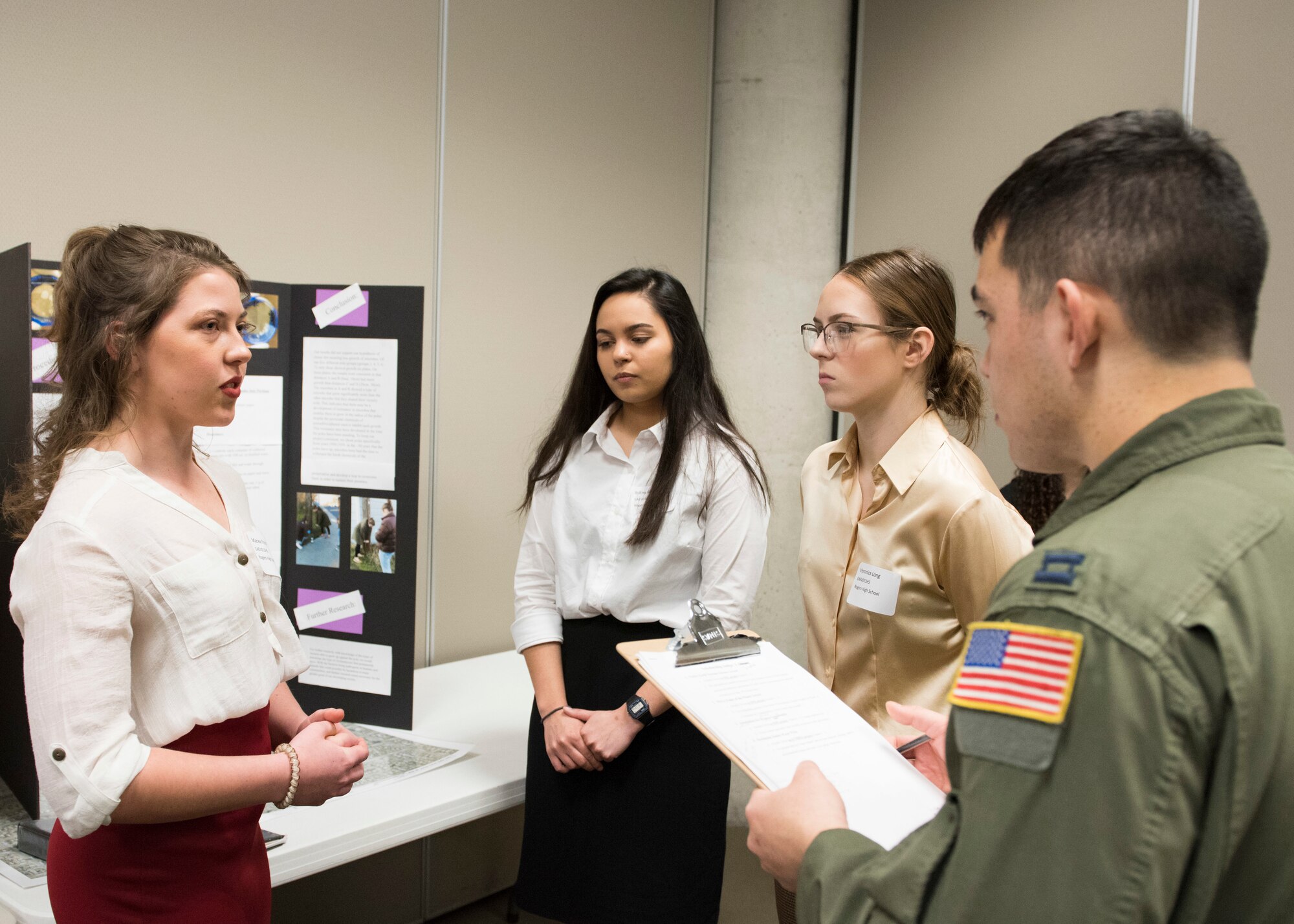 Capt. Joseph Springfield, 384th Air Refueling Squadron pilot, reviews the a project during the Eastern Washington Regional Science and Engineering Fair at the Spokane Washington State University campus, Washington, March 15, 2018. Team Fairchild officers and Airmen were invited by WSU to help with the preliminary judging of the students projects. (U.S. Air Force photo/Senior Airman Ryan Lackey)