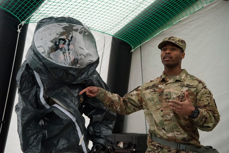 U.S. Army Cpl. Jonathan Bodyen, 773rd Civil Support Team survey team member, explains the capabilities of the hazardous-material suit to U.S. Airmen and U.S. Army Reserve personnel on Ramstein Air Base, Germany, March 12, 2018. The hazardous-material suit offers protection against gases and liquids. The suit is used in situations when personnel are in potentially harmful environements.