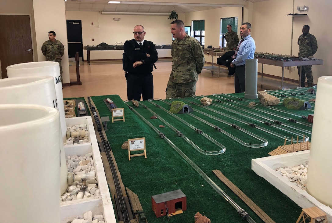 Instructor Staff Sgt. Ricky Ivey describes the fuel system supply point used by the military in tactical operations to French Le Service des Essences des Armées officer Major Mathieu Picquenard.