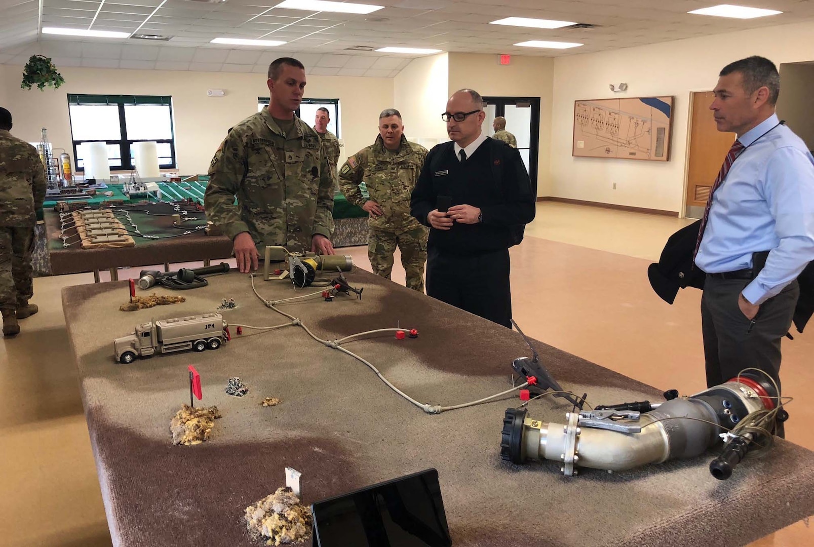 Instructor Staff Sgt. Tyler Butterfield explains the HEMTT Tanker Aviation Refueling System to French Le Service des Essences des Armées officer Major Mathieu Picquenard.