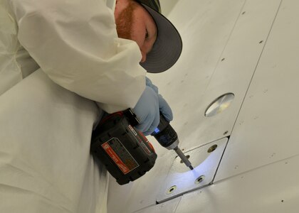 A NASA maintenance worker tightens screws on the NASA Orion crew module at Joint Base Langley-Eustis, Virginia, Feb. 7, 2018.