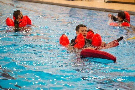 Survival, evasion, resistance and escape specialists with the 3rd Operations Support Squadron conduct a water-survival refresher course for pilots and aircrew at the Elmendorf Fitness Center on Joint Base Elmendorf-Richardson, Alaska, March 20, 2018. The course consisted of safely escaping from under a parachute, using recovery tools, simulating a parachute drag, and various other techniques.