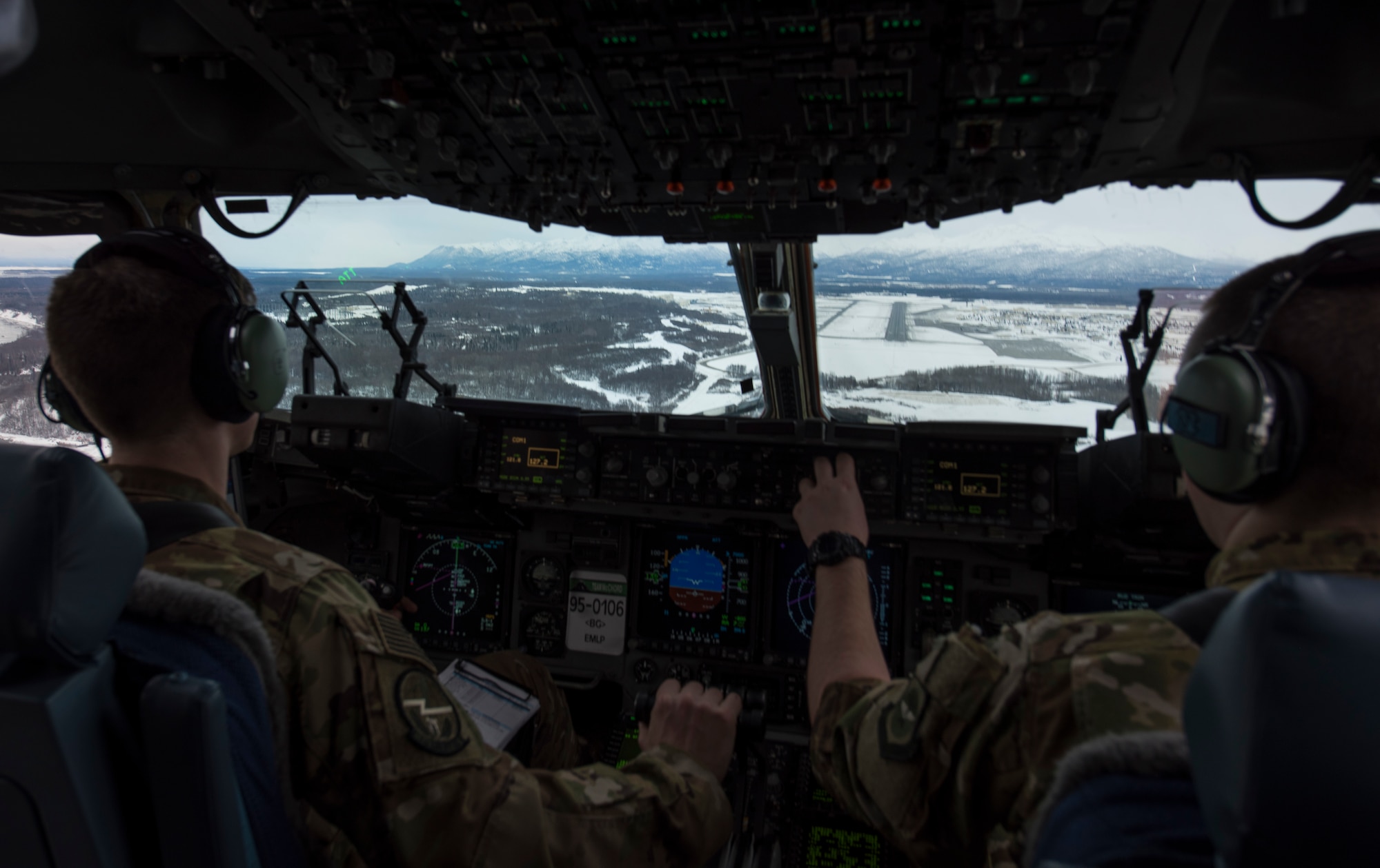 U.S. Air Force Capt. Alex Hoffman (left), 7th Airlift Squadron pilot, and Capt. Richard Elliot, 8th Airlift Squadron instructor pilot, begin a decent in a C-17 Globemaster III to Eielson Air Force Base, Alaska, March 11, 2018. Airmen assigned to the 62nd Airlift Wing flew to Eielson as part of Exercise Arctic Pegasus to practice cold-weather operations. (U.S. Air Force photo by Senior Airman Tryphena Mayhugh)