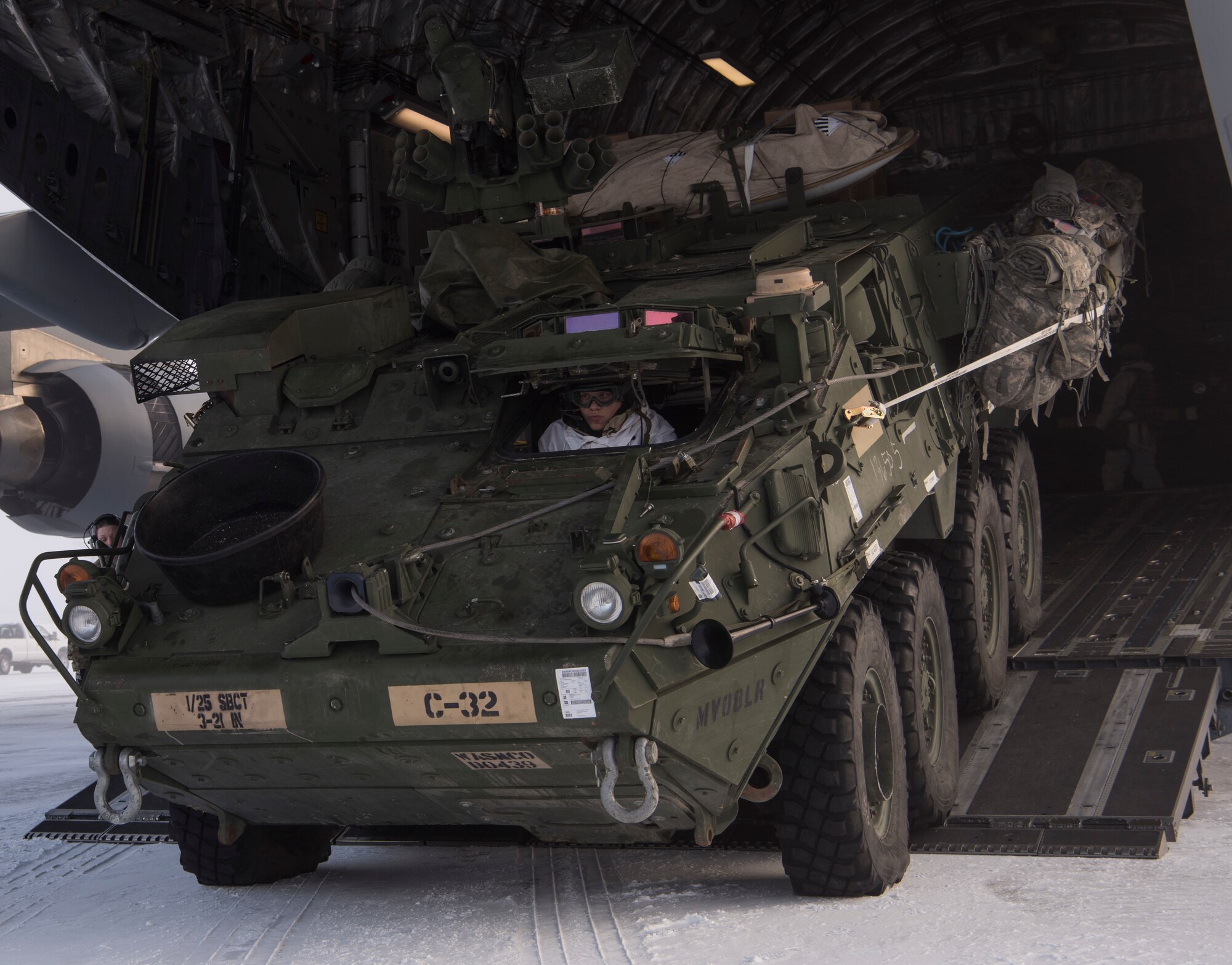 A U.S. Army Soldier drives an Interim Armored Vehicle Stryker out of a C-17 Globemaster III during Exercise Arctic Pegasus at Deadhorse, Alaska, March 13, 2018. The 62nd Airlift Wing participated in the exercise by transporting Soldiers and Strykers from Eielson Air Force Base, Alaska, to Deadhorse. (U.S. Air Force photo by Senior Airman Tryphena Mayhugh)