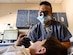 Captain Jeffrey Yee, 628th Aeromedical Squadron general dentist, examines a patient’s mouth during the Give Kids A Smile event at Joint Base Charleston, S.C., March 23, 2018.