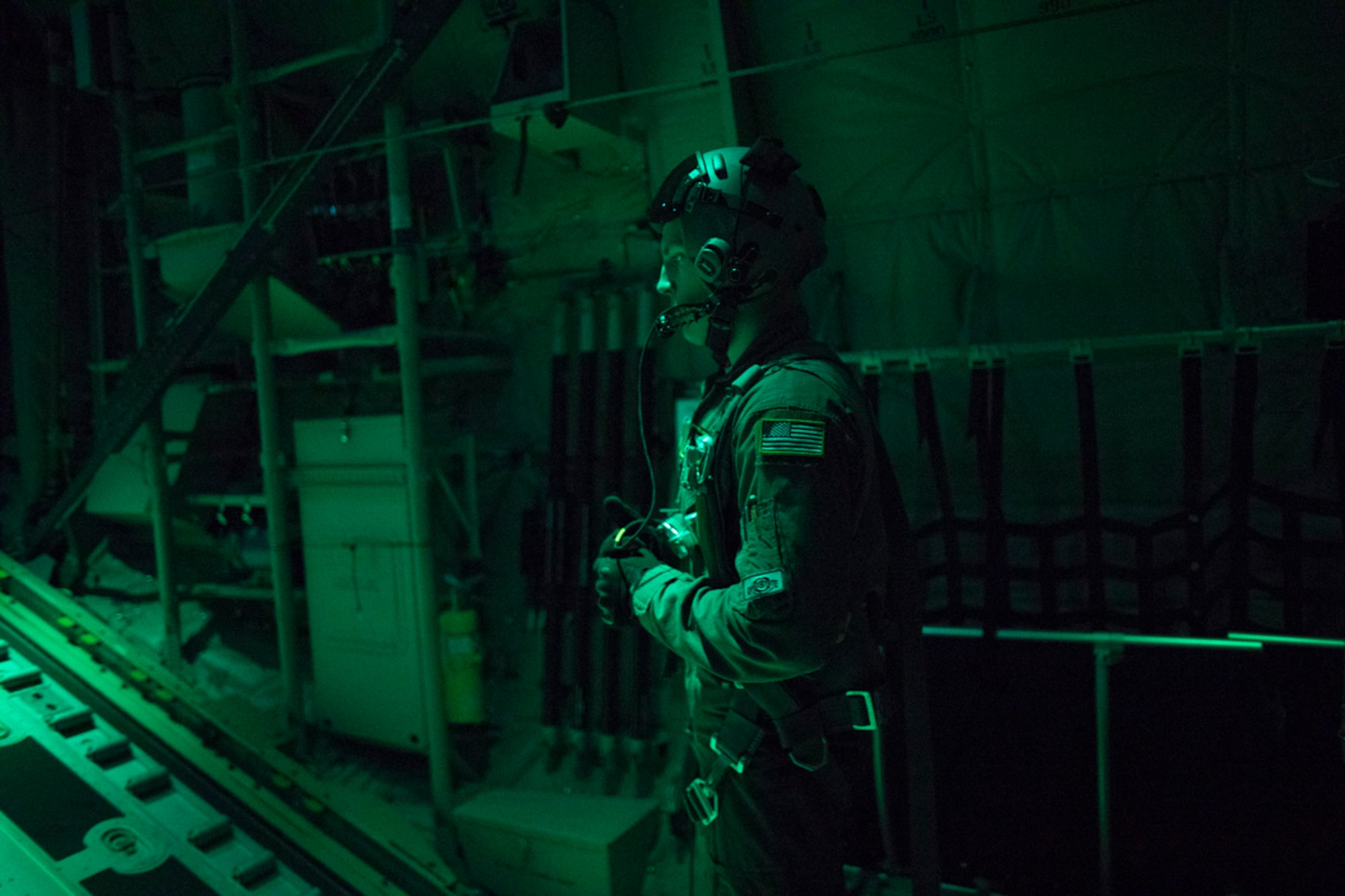 Airman 1st Class Matthew Pfeffer, 36th Airlift Squadron C-130J loadmaster, communicates with aircrew during a training mission over the Kanto Plain