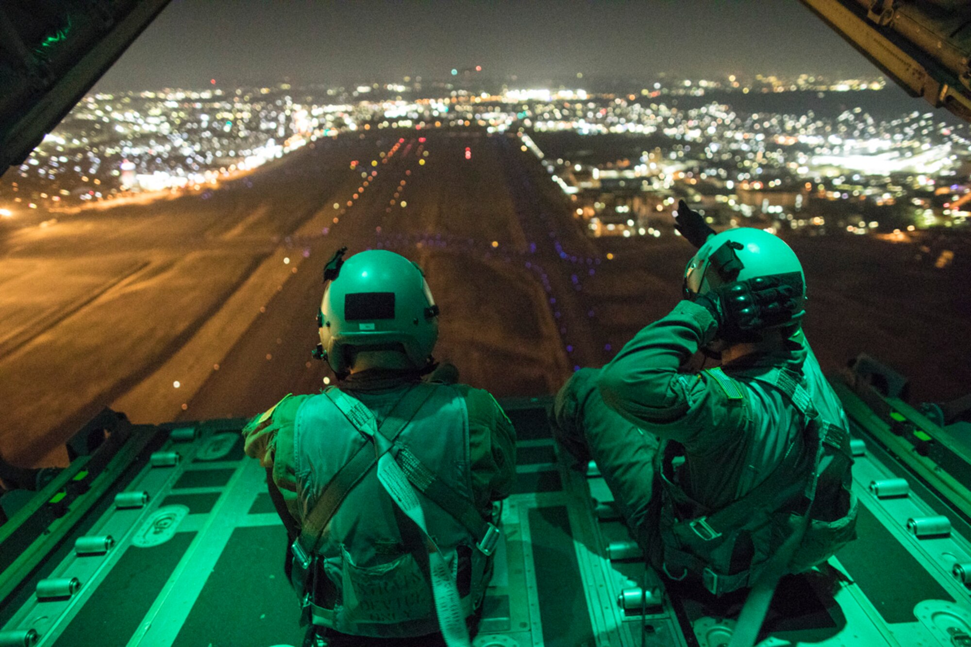 Senior Airman Stephen Clark and Airman 1st Class Matthew Pfeffer, 36th Airlift Squadron C-130J loadmaster, perform a simulated airdrop over Yokota Air Base, Japan, March 26, 2018
