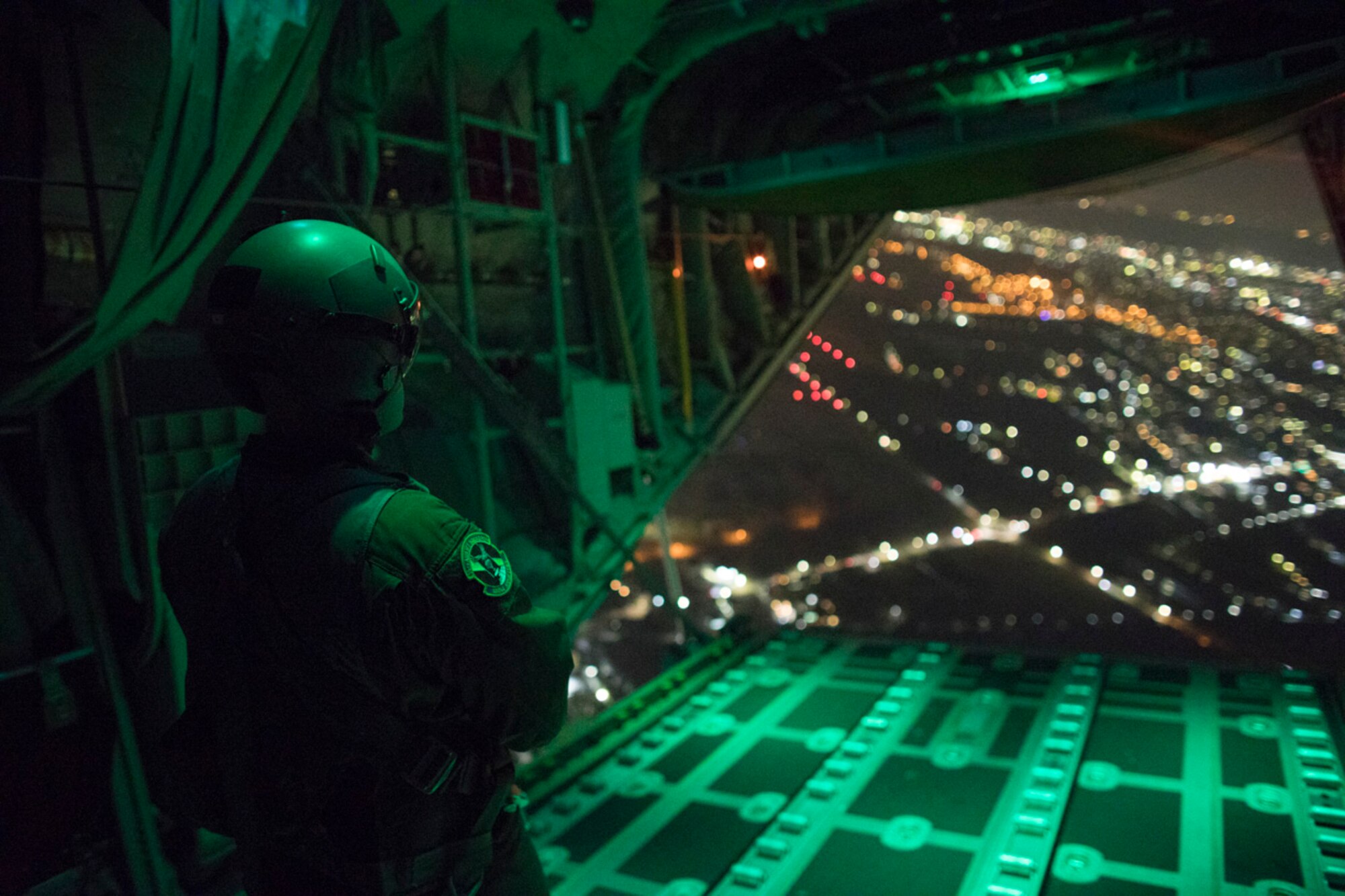 Senior Airman Stephen Clark, 36th Airlift Squadron C-130J loadmaster, observes the ramp while it closes during a training mission over Yokota Air Base