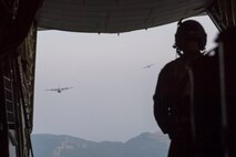 Airman 1st Class Matthew Pfeffer, 36th Airlift Squadron C-130J loadmaster, observes two Air Force C-130J Super Hercules over the Combined Arms Training Center Camp Fuji