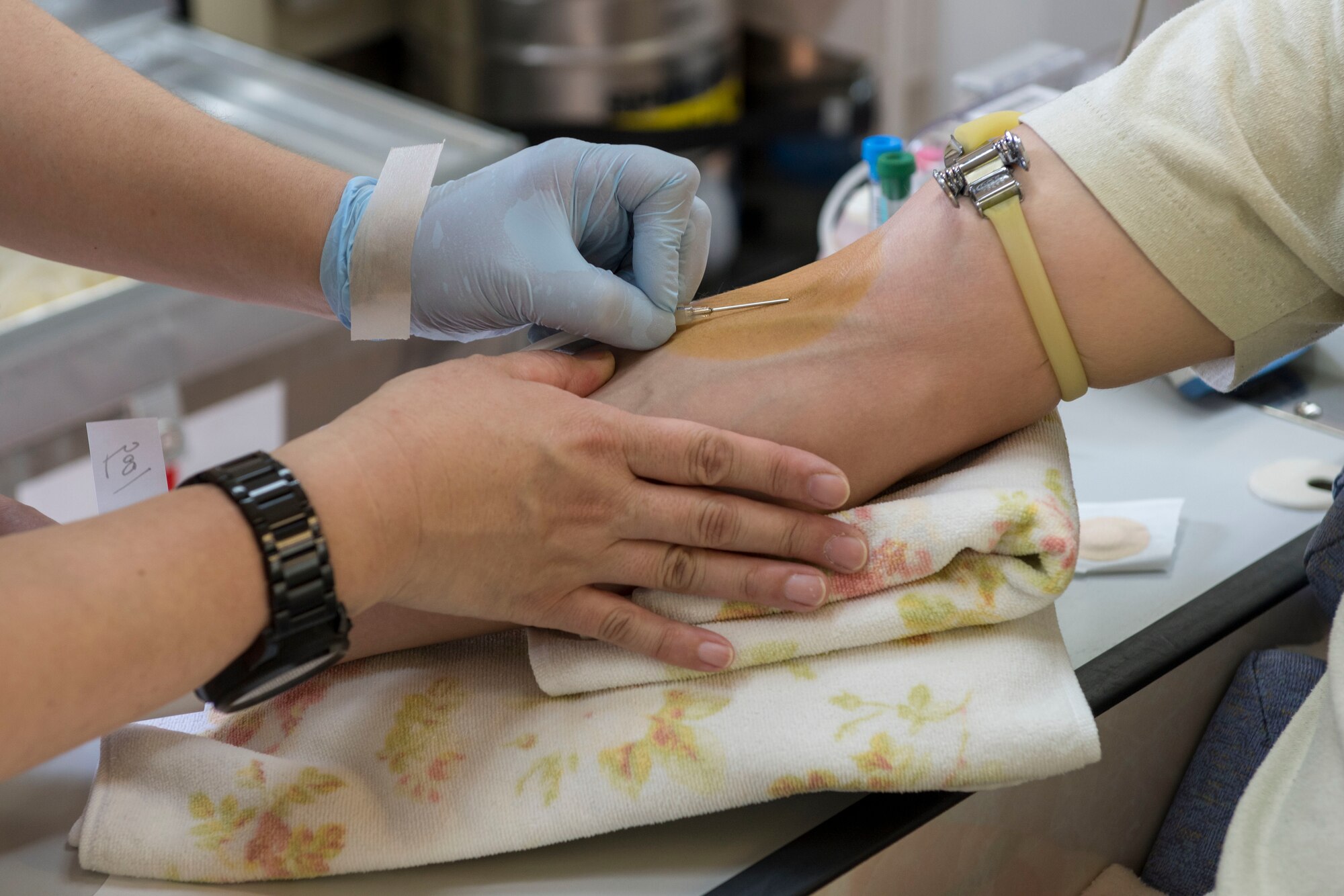 A member of the Japanese Red Cross Society team begins to insert a needle to begin the blood donation process at Yokota Air Base, March 28, 2018.
