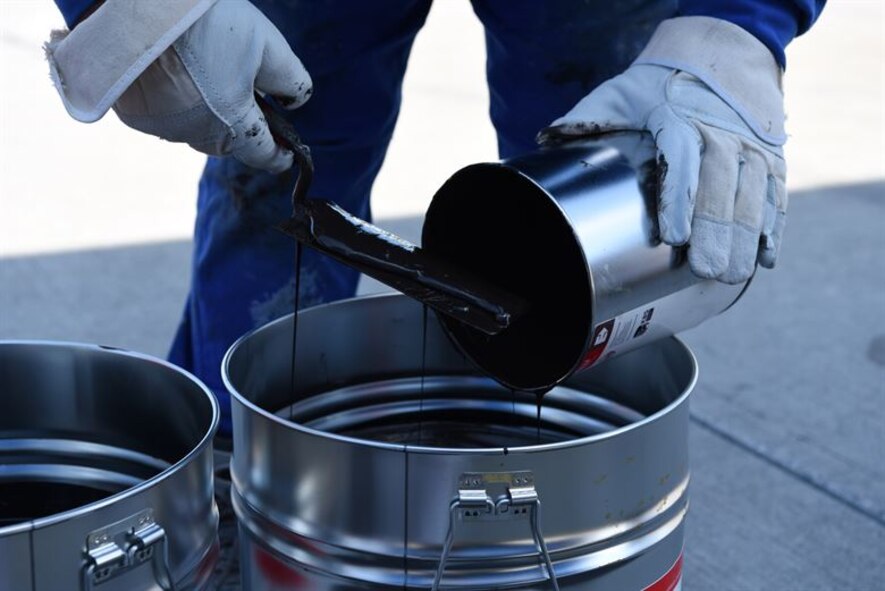 A German contractor mixes tar that will be placed in the drains of the flightline on Ramstein Air Base, Sept. 21, 2017. Once on-site, the tar was blended together into bigger containers.