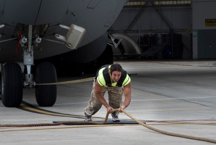 Mark Kirsch, strong man for “Man vs. Impossible,” pulls a C-17 Globemaster III from a hangar at Joint Base Charleston, S.C., March 27, 2018.