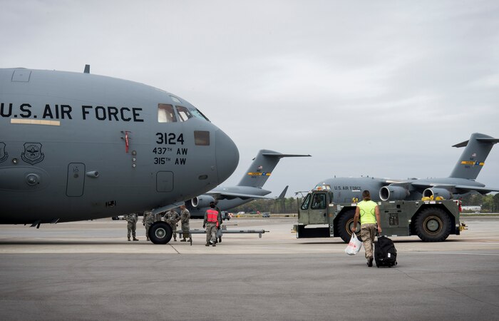 Airmen from the 437th Aircraft Maintenance Squadron and Mark Kirsch, strong man for “Man vs. Impossible,” setup for a practice session of pulling a C-17 Globemaster III from a hangar at Joint Base Charleston, S.C., March 27, 2018.