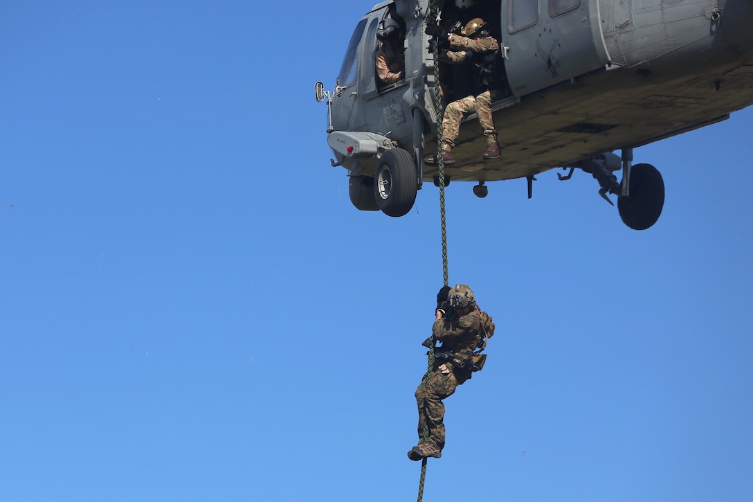 A Marine rappels from a helicopter.