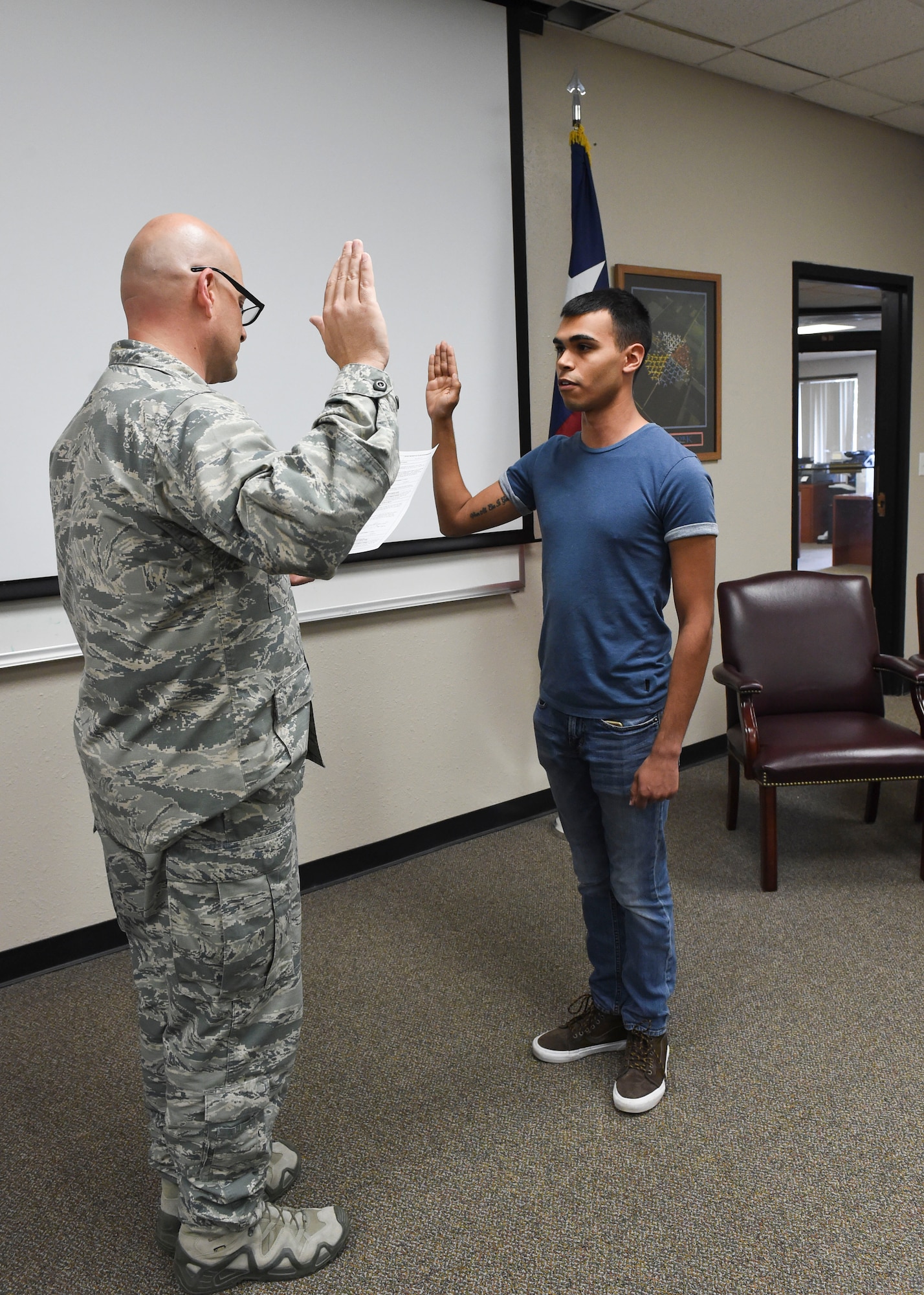 Lt. Col. John Pollard, the 149th Security Forces Squadron commander, swears Nathaniel Mauricio into the Air National Guard