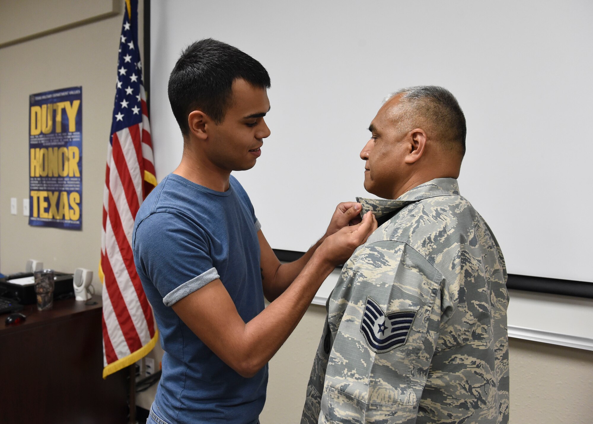 Nathaniel Mauricio fastens a retirement pin onto his father, Tech. Sgt. Manuel Mauricio, who retired after 27 years of service with the 149th Fighter Wing’s Security Forces Squadr