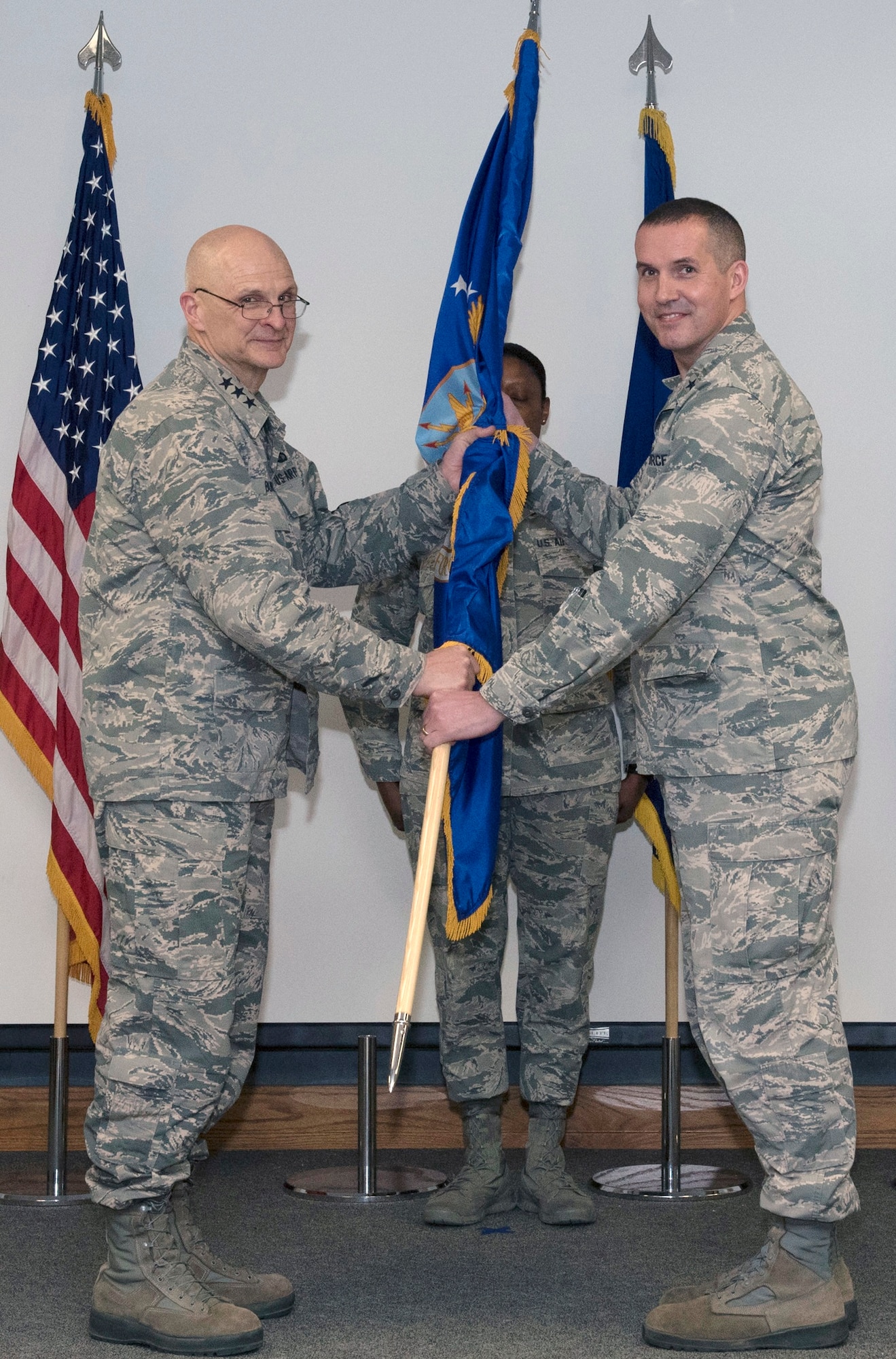 Lt. Gen. Arnold Bunch, Military Deputy, Office of the Assistant Secretary of the Air Force for Acquisition (L) pass the guidon to Brig. Gen. Heath Collins (R) during a March 28 change of leadership ceremony. Collins is the new Program Executive Officer for the Fighters and Bombers Directorate and is responsible for the development, production, fielding sustainment and modernization of fighters and bombers throughout the Air Force. (U.S Air Force photo / Michelle Gigante)