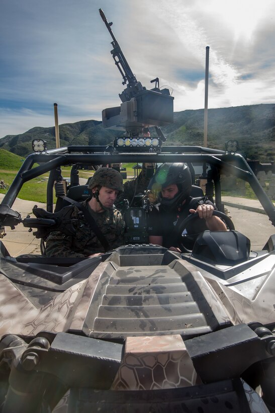 A senior officer test drives an electric tactical vehicle.