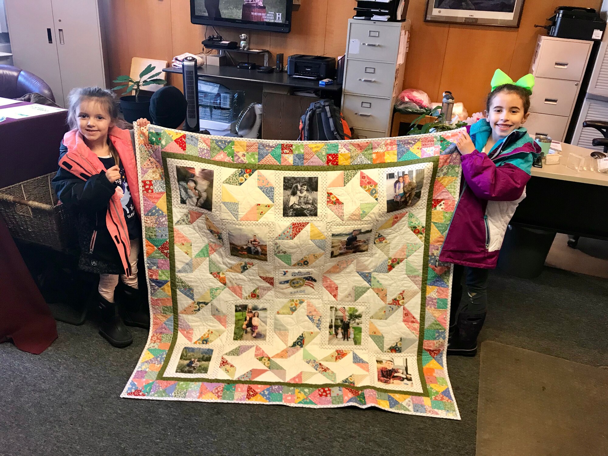 Brooke, age 4 and Khloe, age 6, daughters of Army Staff Sgt. Terry Porter, receive quilts from Operation Kid Comfort coordinated through the Armed Services YMCA of Alaska at the Joint Base Elmendorf-Richardson branch, March 7, 2018. Program volunteers at the ASYMCA of Alaska coordinate with local quilting groups to create custom-made photo-transfer quilts and pillow cases for the children of deployed active-duty service members.