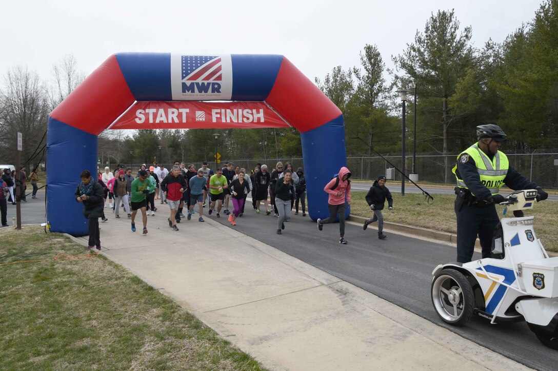Runners and walkers leave the starting line at the annual 'Honor the Warrior' 5K event at the McNamara Headquarters Complex, Fort Belvoir, Virginia, March 28, 2018.