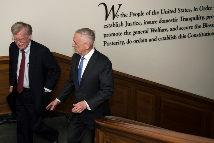 Defense Secretary James N. Mattis walks up the stairs with another person.