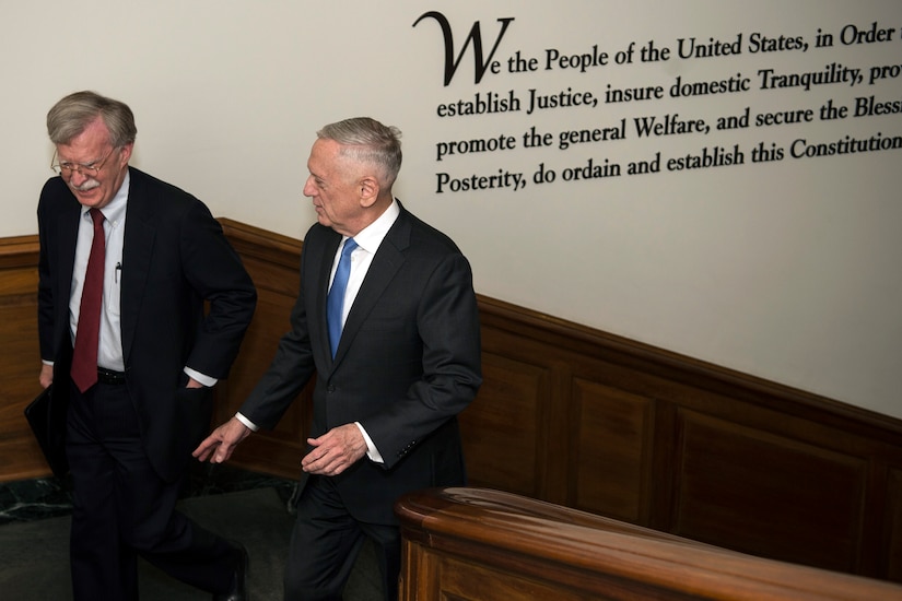 Defense Secretary James N. Mattis walks up the stairs with another person.