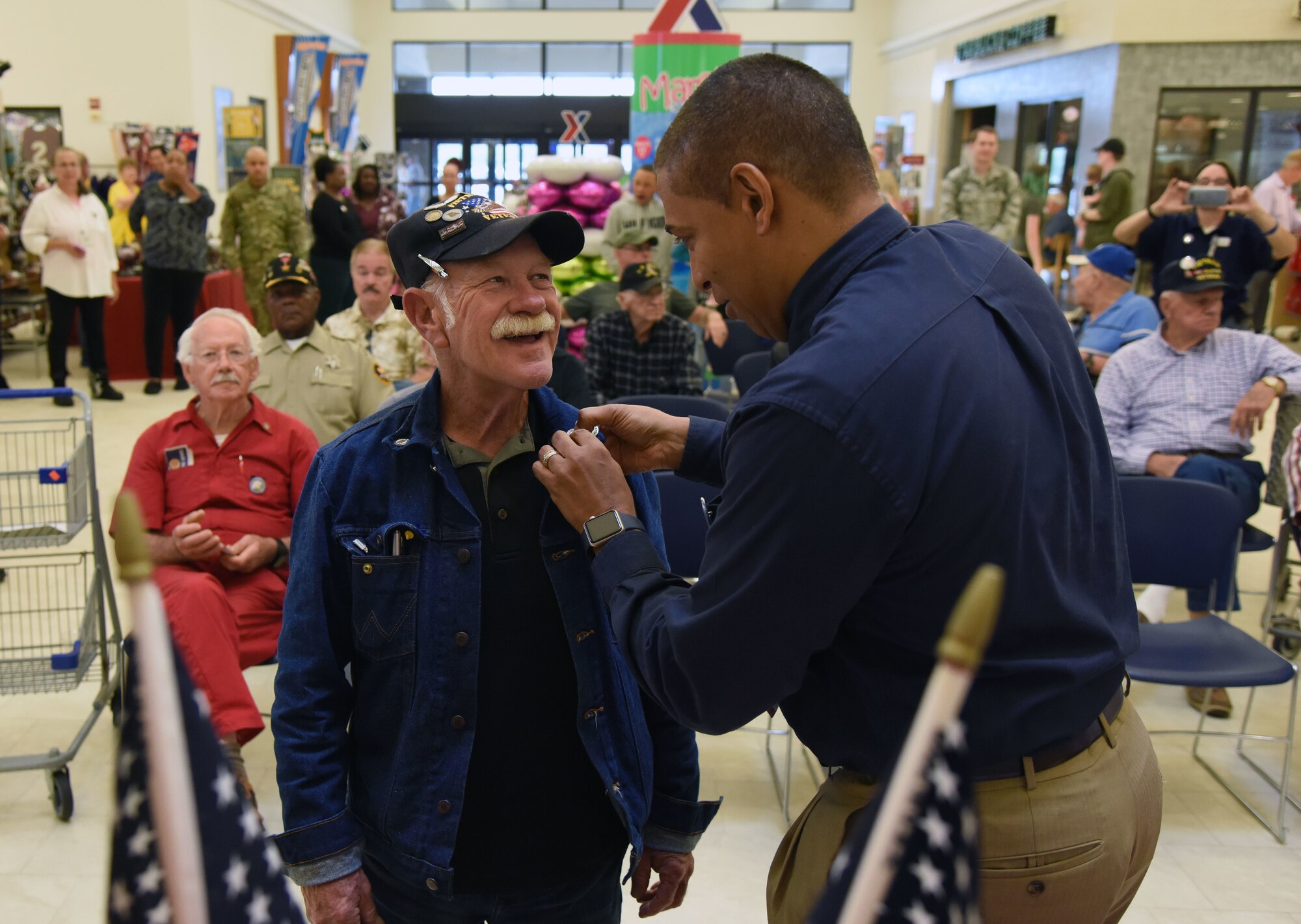 Gregory Hall, Keesler Base Exchange general manager, presents a lapel pin to Roger Anderson, U.S. Navy Vietnam veteran, during the 50th Anniversary Vietnam Memorial Pinning Day at The Exchange March 29, 2018, on Keesler Air Force Base, Mississippi. The event, which also included a cake cutting ceremony, was held to honor Vietnam veterans for their service. (U.S. Air Force photo by Kemberly Groue)
