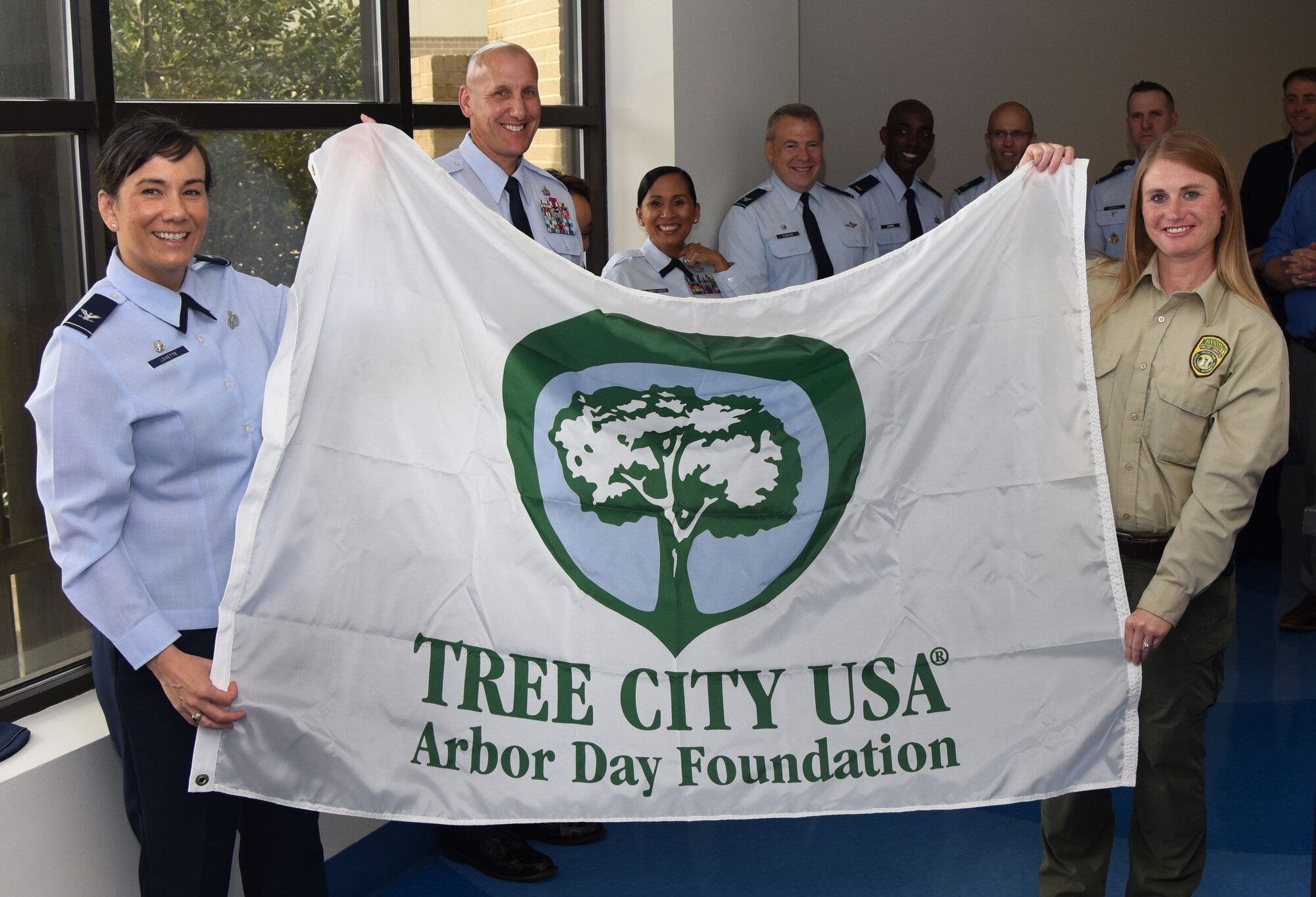 U.S. Air Force Col. Debra Lovette, 81st Training Wing commander, and Kelly Griffin, Harrison County Beautification Commission executive director, hold a Tree City USA flag during the Arbor Day Ceremony at the Keesler Child Development Center March 29, 2018, on Keesler Air Force Base, Mississippi. This is the 25th consecutive year Keesler has received the Tree City USA award. Arbor Day is a nationally celebrated observance that focuses on environmental issues and ways to improve the environment. (U.S. Air Force photo by Kemberly Groue)