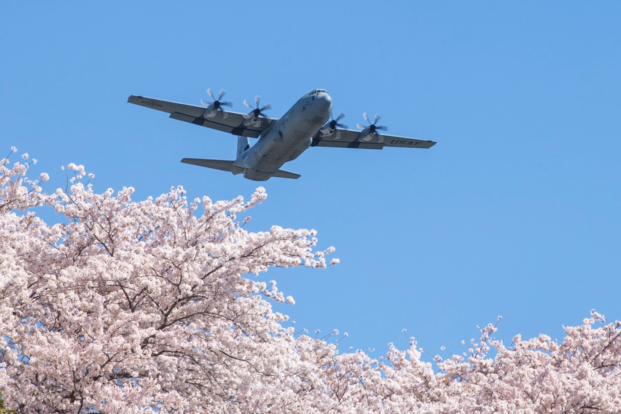 An Air Force C-130J Super Hercules assigned to the 36th Airlift Squadron flies over Yokota Air Base