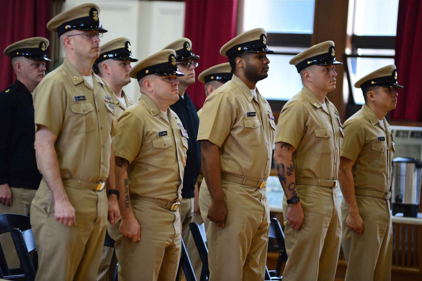 Chief Petty Officers from U.S. Seventh Fleet stand at attention for the reading of the Chief’s Creed during a commemoration ceremony in honor of the 125th anniversary of the birth of the chief rank.