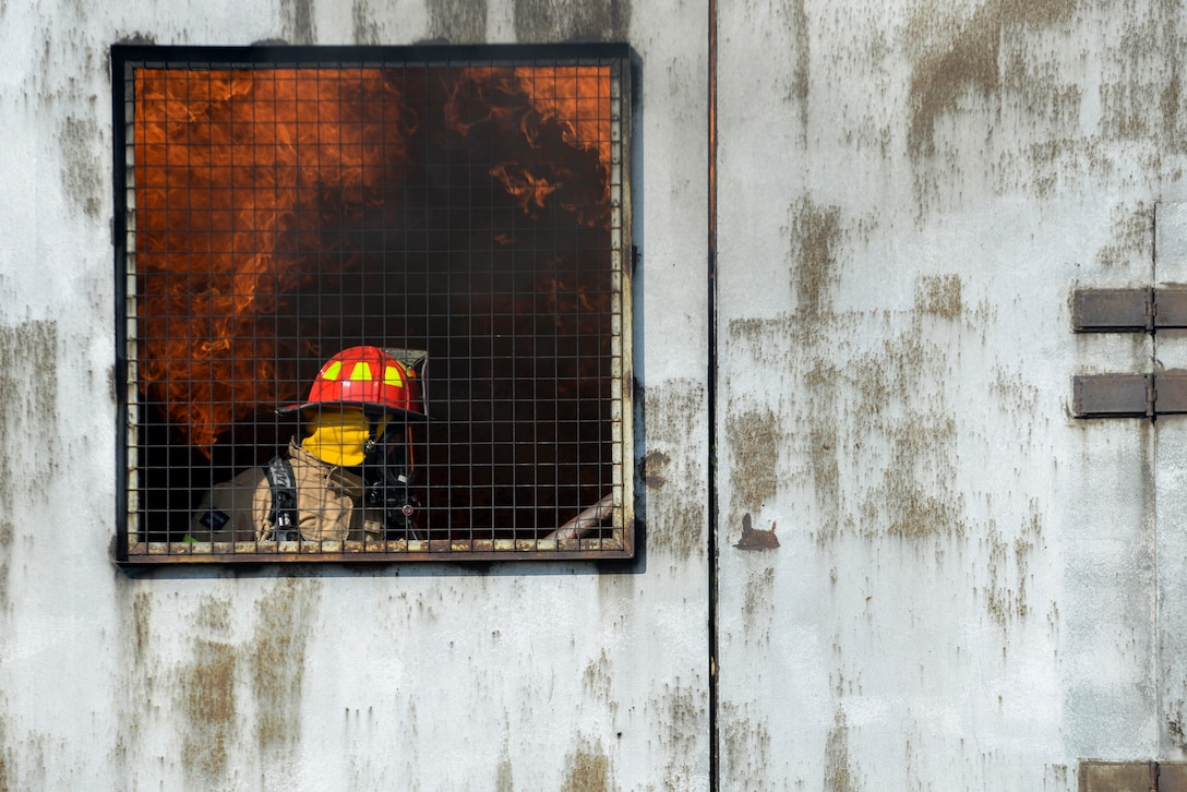 A 100th Civil Engineer Squadron firefighter extinguishes a fire inside a mock aircraft, as part of annual proficiency skill training at a burn pit at RAF Mildenhall, England, March 21, 2018. All firefighters are required to conduct live-fire training at least twice a year to stay proficient and keep their qualifications current. (U.S. Air Force photo by Tech. Sgt. Emerson Nuñez)