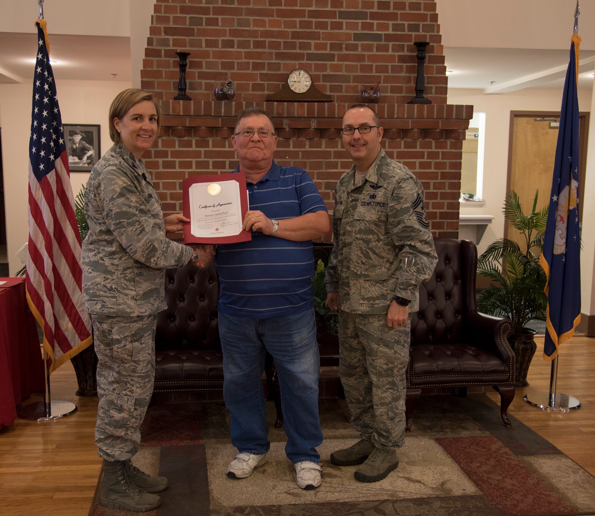 Dennis Charmichael, an American Red Cross volunteer, receives his certificate from Col Jennifer Short, 23d Wing commander, at a volunteer appreciation luncheon, March 26, 2018, at Moody Air Force Base, Ga. Volunteers from Moody were recognized for their service to the American Red Cross. (U.S. Air Force photo by 1st Lt. Kaitlin Toner)