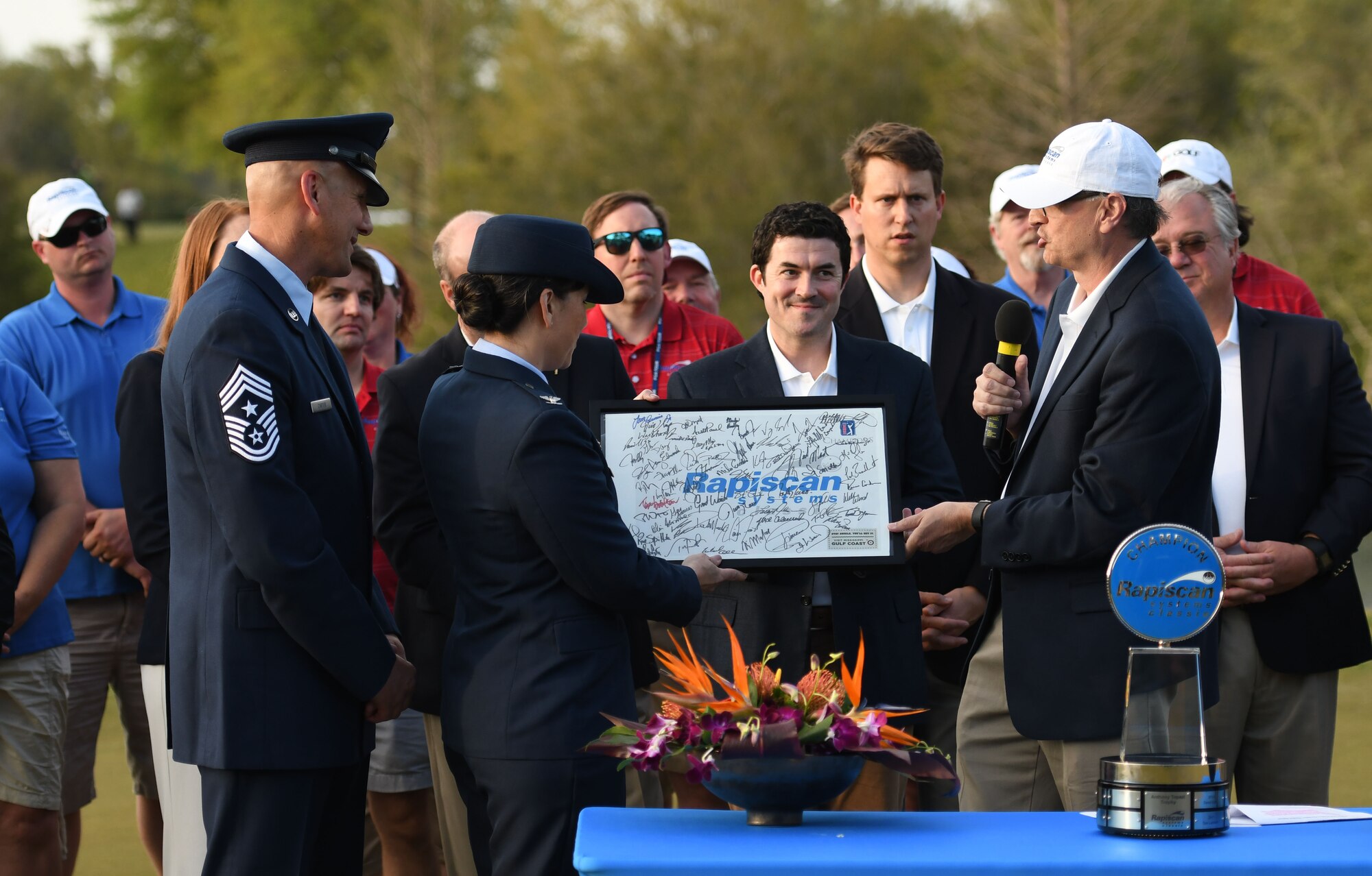Ajay Mehra, Rapiscan Systems president, presents U.S. Air Force Col. Debra Lovette, 81st Training Wing commander and Chief Master Sgt. Kenneth Carter, Jr., 81st TRW command chief, with a memento during the Rapiscan Systems Classic Champions Tour at Fallen Oak Golf Club March 25, 2018, in Saucier, Mississippi. Keesler personnel performed the national anthem and presented the colors during the closing ceremony of the three-day event. (U.S. Air Force photo by Kemberly Groue)