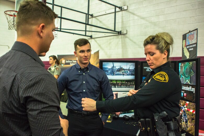 A Contra Costa County Sheriff shows Marines the Sheriff’s Department tattoo regulations during the Education & Career Fair aboard the Marine Corps Air Ground Combat Center, Twentynine Palms, Calif., March 21, 2018. The Education & Career Fair is a tool for Marines looking to further their education, develop new skills and explore new career fields. (U.S. Marine Corps photo by Lance Cpl. Rachel K. Porter)