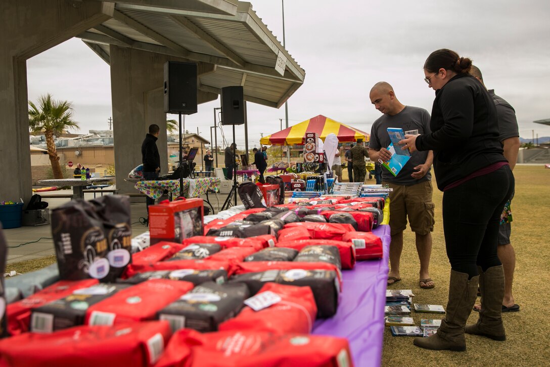 Marines, sailors and spouses of 1st Battalion, 7th Marine Regiment, look at raffle prizes during spring family day at Victory Field aboard the Marine Corps Air Ground Combat Center, Twentynine Palms, Calif., March 24, 2018. The unit family readiness officer hosts events like spring family day to enhance camaraderie, bring spouses together to form positive relationships and create activities for the children. (U.S. Marine Corps photo by Lance Cpl. Margaret Gale)