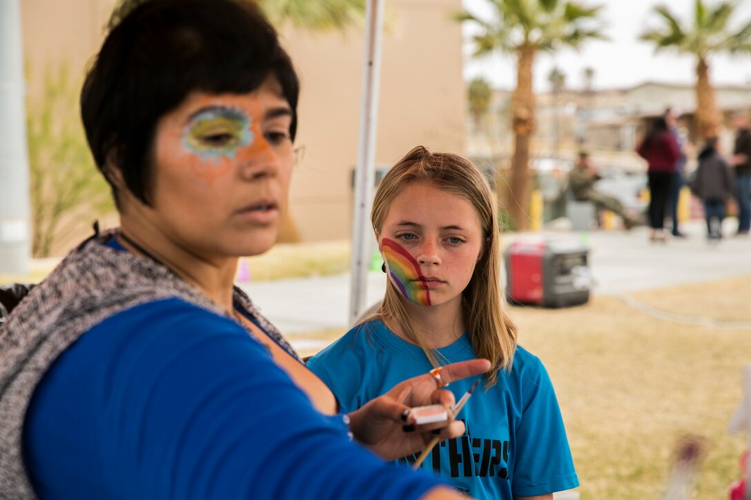 Skyler Sholl (right), 12, Combat Center patron, gets her face painted by Laura Rivas (left), special effects artist, during a spring family day at Victory Field aboard the Marine Corps Air Ground Combat Center, Twentynine Palms, Calif., March 24, 2018. The unit family readiness officer hosts events like spring family day to enhance camaraderie, bring spouses together to form positive relationships and create activities for the children. (U.S. Marine Corps photo by Lance Cpl. Margaret Gale)
