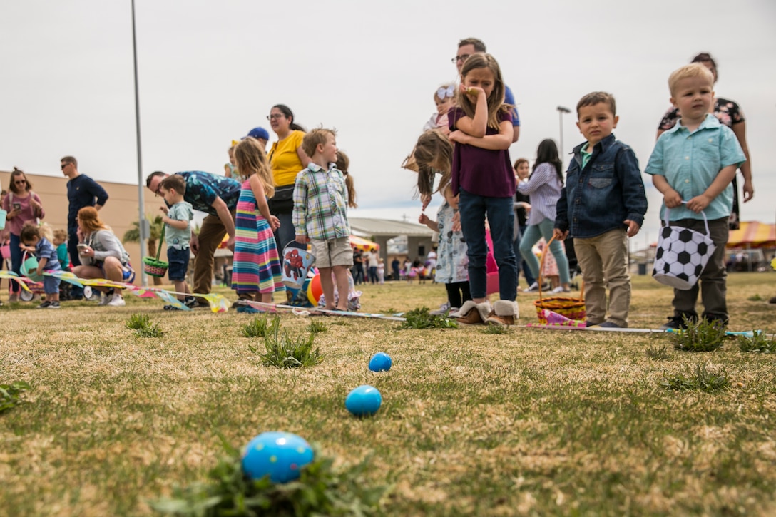 Children of Marines and sailors  with 1st Battalion, 7th Marine Regiment, line up to begin an Easter egg hunt during a spring family day at Victory Field aboard the Marine Corps Air Ground Combat Center, Twentynine Palms, Calif., March 24, 2018. The unit family readiness officer hosts events like spring family day to enhance camaraderie, bring spouses together to form positive relationships and create activities for the children. (U.S. Marine Corps photo by Lance Cpl. Margaret Gale)