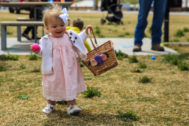 Piper Wetherill, daughter of Capt. Sean Wetherill, logistics officer, 1st Battalion, 7th Marine Regiment, participates in an Easter egg hunt during a spring family day at Victory Field aboard the Marine Corps Air Ground Combat Center, Twentynine Palms, Calif., March 24, 2018. The unit family readiness officer hosts events like spring family day to enhance camaraderie, bring spouses together to form positive relationships and create activities for the children. (U.S. Marine Corps photo by Lance Cpl. Margaret Gale)