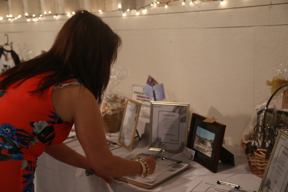 A guest at the Havana Nights Gala & Benefit Auction makes a bid before the auction at Smith’s Ranch in Twentynine Palms, Calif., March 24, 2018. Havana Nights is an annual benefit auction hosted by the Officers’ Spouses’ Club to raise money for their Scholarship Grant Program, which provides community members with grants to continue their education. (U.S. Marine Corps photo by Lance Cpl. Preston L. Morris)