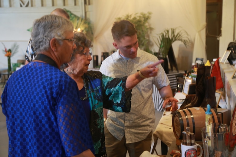 Guests look at one of many auction bundles during the Havana Nights Gala & Benefit Auction hosted by Smith’s Ranch in Twentynine Palms, Calif., March 24, 2018. Havana Nights is an annual benefit auction hosted by the Officers’ Spouses’ Club to raise money for their Scholarship Grant Program, which provides community members with grants to continue their education. (U.S. Marine Corps photo by Lance Cpl. Preston L. Morris)