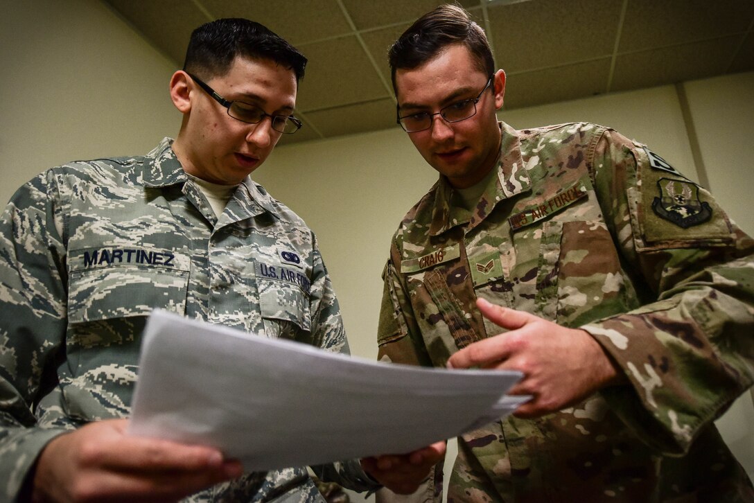 U.S. Air Force Staff Sgt. Justin Martinez, 20th Security Forces Squadron (SFS) unit deployment manager, left, and Senior Airman Michael Craig, 20th SFS installation patrolman, inspect a pre-deployment checklist at Shaw Air Force Base, S.C., March 29, 2018.