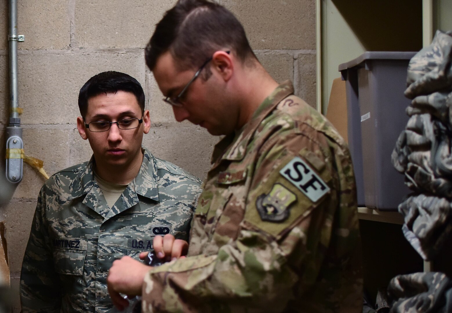 U.S. Air Force Senior Airman Michael Craig, 20th Security Forces Squadron (SFS) installation patrolman, right, inspects an item for serviceability as Staff Sgt. Justin Martinez, 20th SFS unit deployment manager, watches at Shaw Air Force Base, S.C., March 29, 2018.
