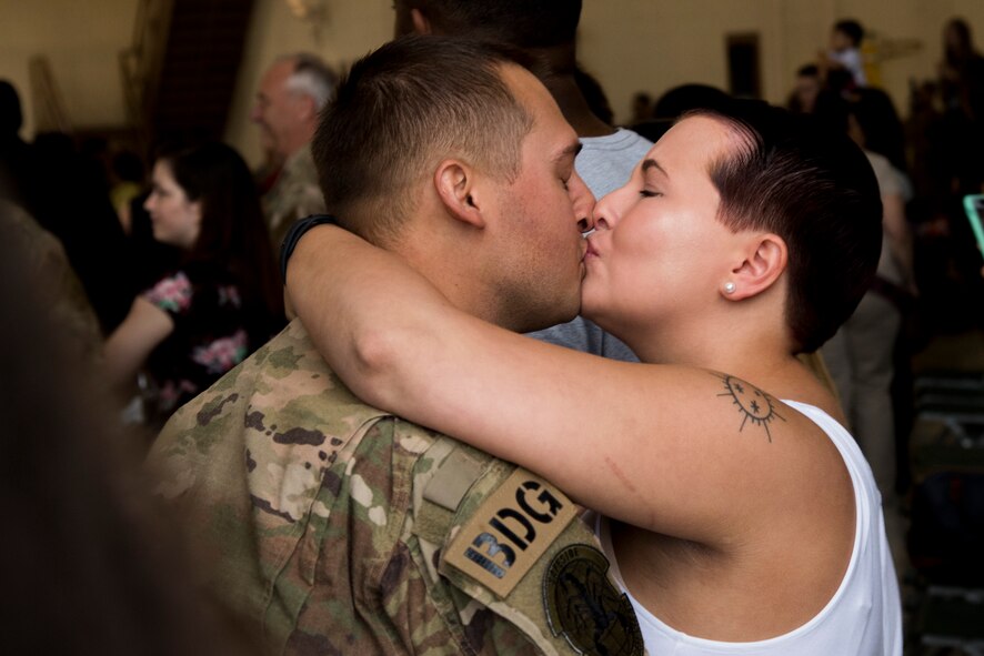 Jess Thompson welcomes back her husband, Airman 1st Class Aaron Thompson, 822nd Base Defense Squadron fire team member, with a kiss during a redeployment March 30, 2018, at Moody Air Force Base, Ga. The 822nd BDS returned after spending several months deployed and earning numerous command, wing and individual awards. (U.S. Air Force photo by Staff Sgt. Eric Summers Jr.)