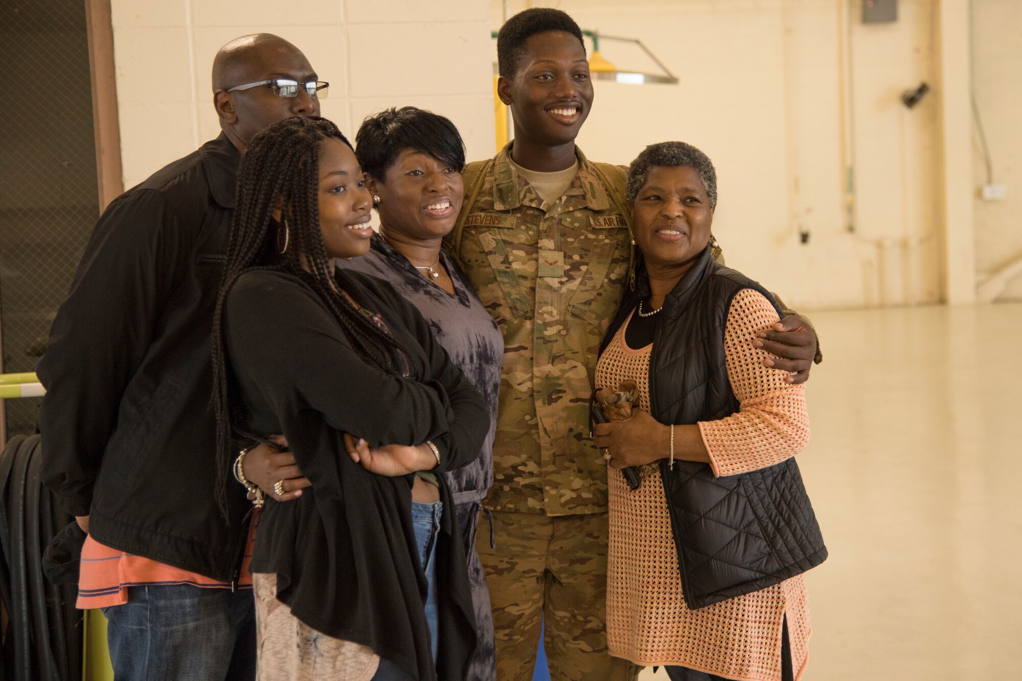 Airman 1st Class Darrius Stevens, 822nd Base Defense Squadron fire team member, takes a photo with his family during a redeployment ceremony March 30, 2018, at Moody Air Force Base, Ga. The 822nd BDS returned after spending several months deployed and earning numerous command, wing and individual awards. (U.S. Air Force photo by Staff Sgt. Eric Summers Jr.)