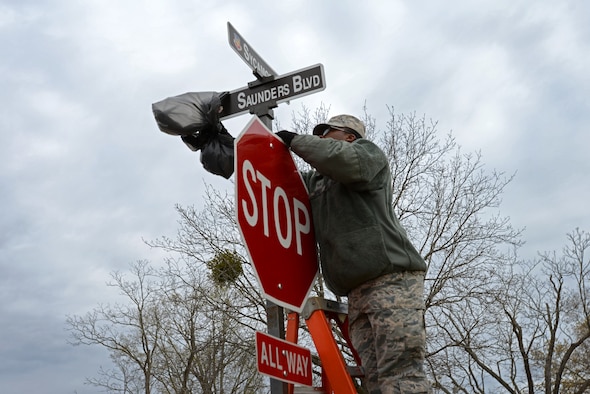 U.S. Air Force Senior Airman Kadeem Joyner, 20th Logistics Readiness Squadron ground transportation journeyman, removes the cover from the new Saunders Boulevard sign at Shaw Air Force Base, S.C., March 26, 2018.